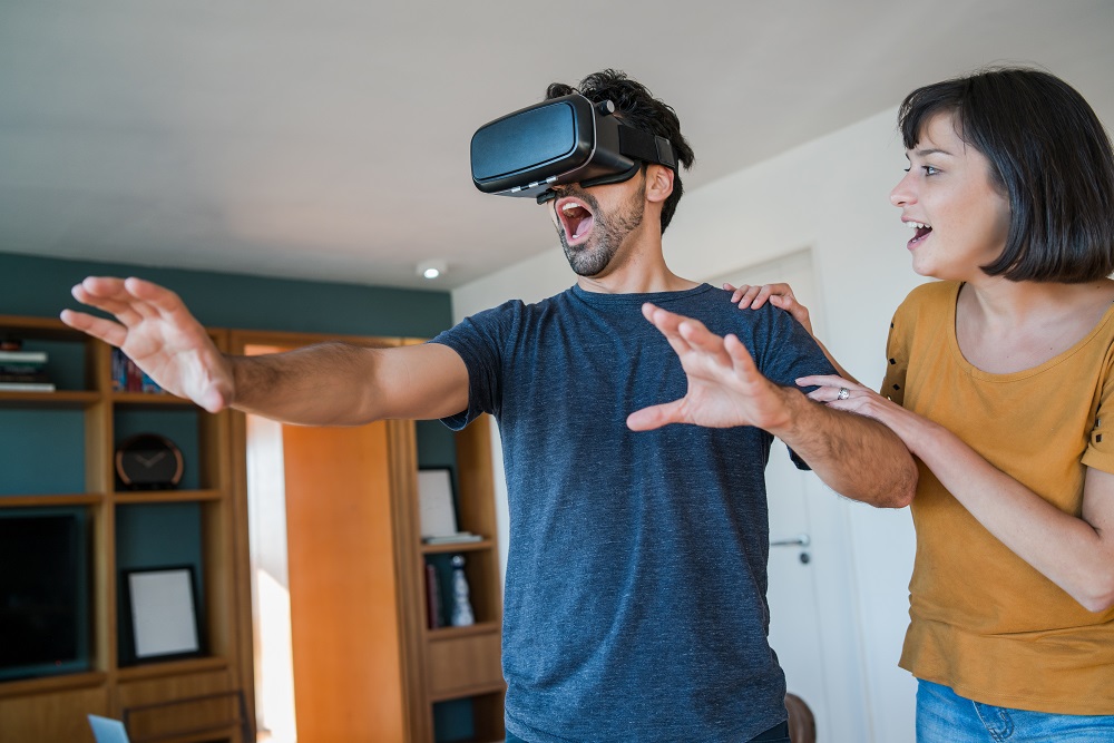 Couple playing video games with Virtual Reality glasses.