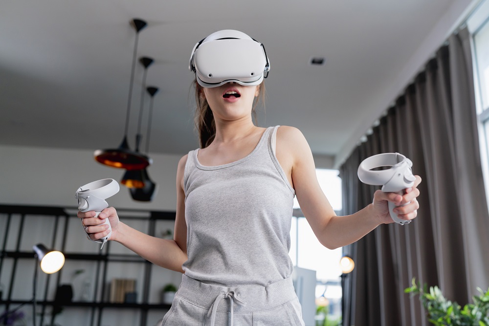 exitied enjoy 3d virtual gaming futuristic experience young asian female wear vr headset technology watching simulation digital world hand gesture control herself to beat the online fun virtual gaming