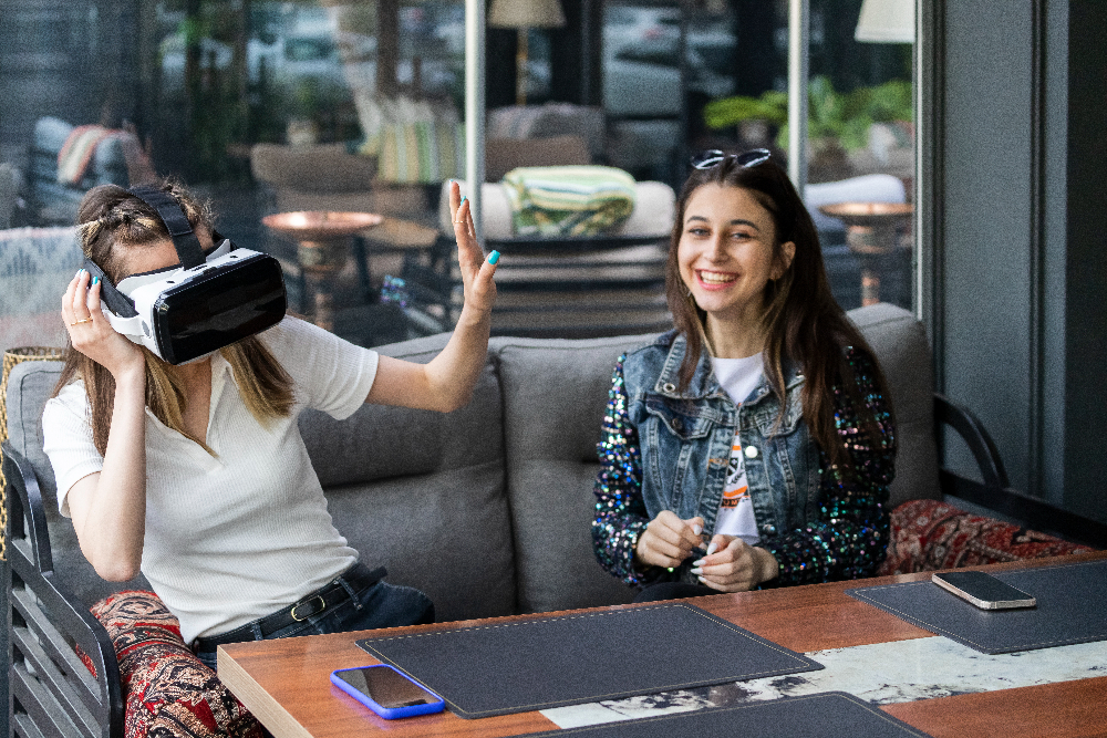 Virtual reality in retail: two girls in a cafe playing with vr glasses